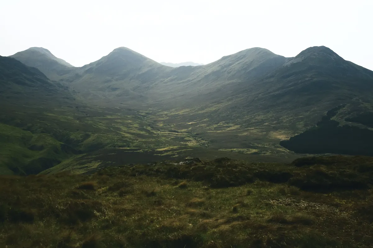 Bare, rocky mountain slopes of the Twelve Bens in Connemara National Park under broken cloud